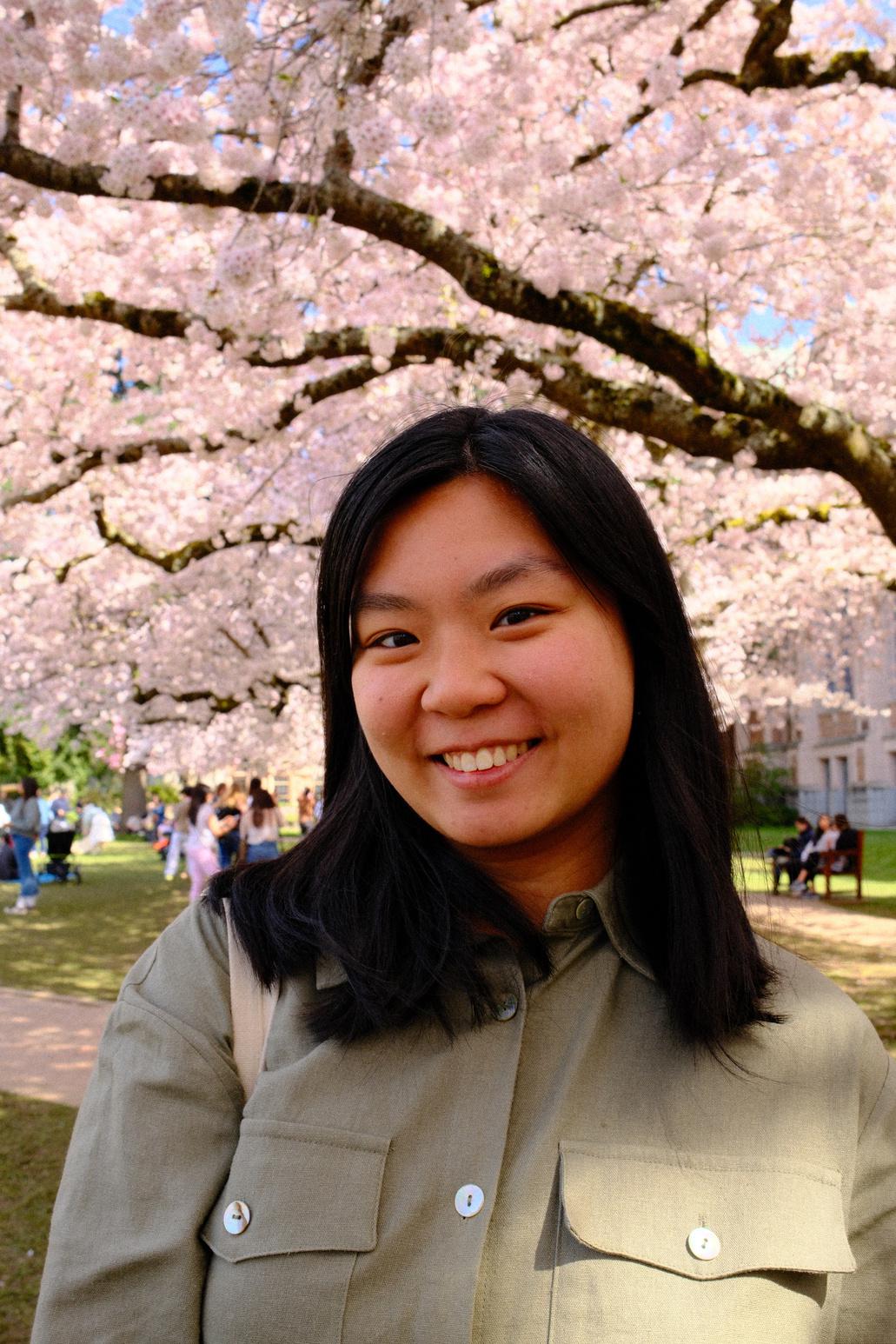 Victoria Chen smiling outdoors with cherry blossoms